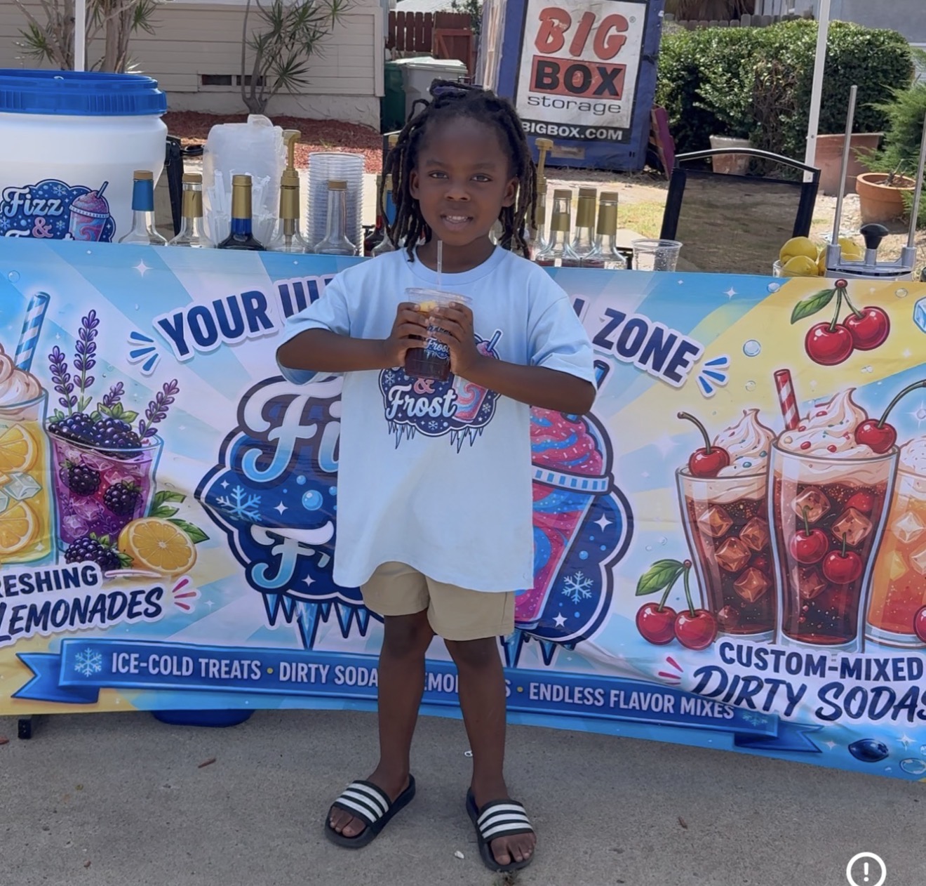 Young customer in a Fizz & Frost tee holding a dirty soda at the stand